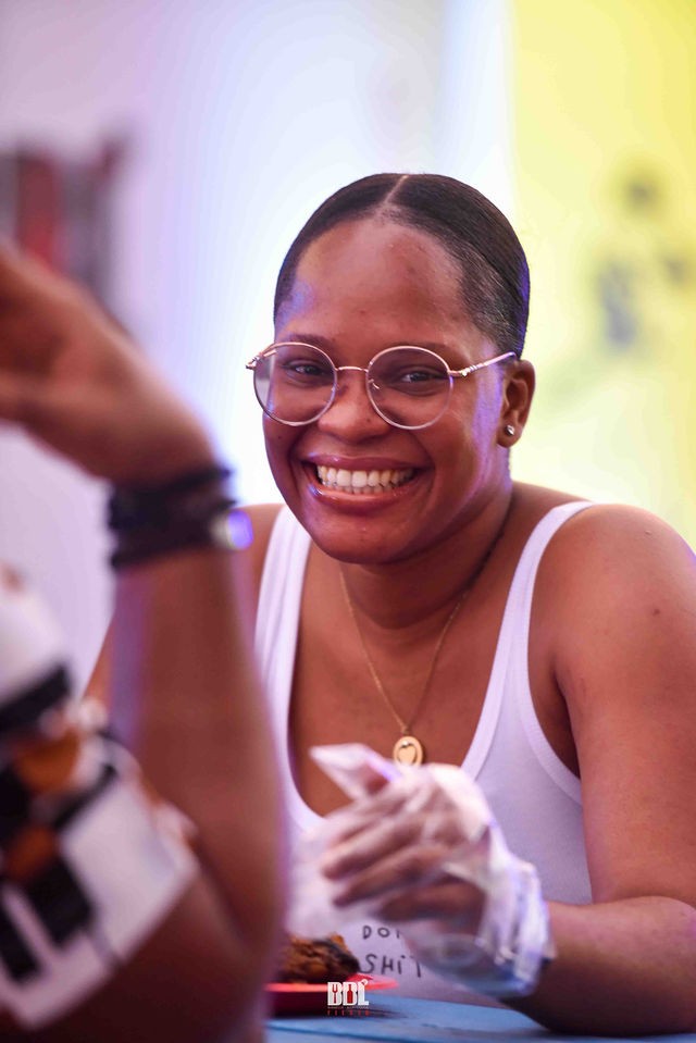 Guest smiling at a food table at BBL Fiesta 2024